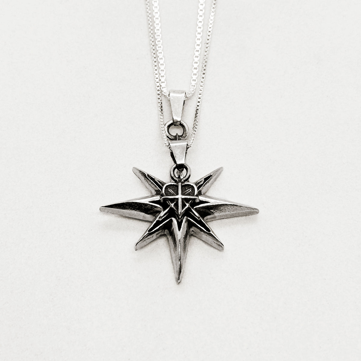 Detalle del dije estrella con el corazón en plata 950 - Flames Army
